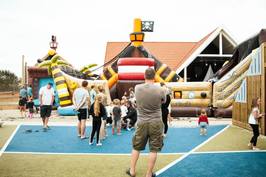 Een piratenschip van avontuur! Kinderen klauteren en spelen op de opblaasbare attractie