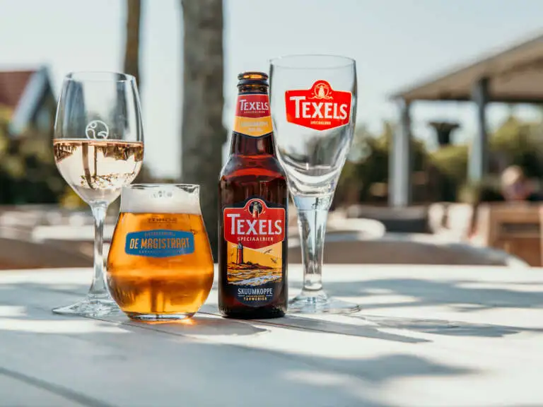 Terrasdrankjes in de zon, een fles Texels Skuumkoppe, een fris glas witte wijn en een ontspannen sfeer