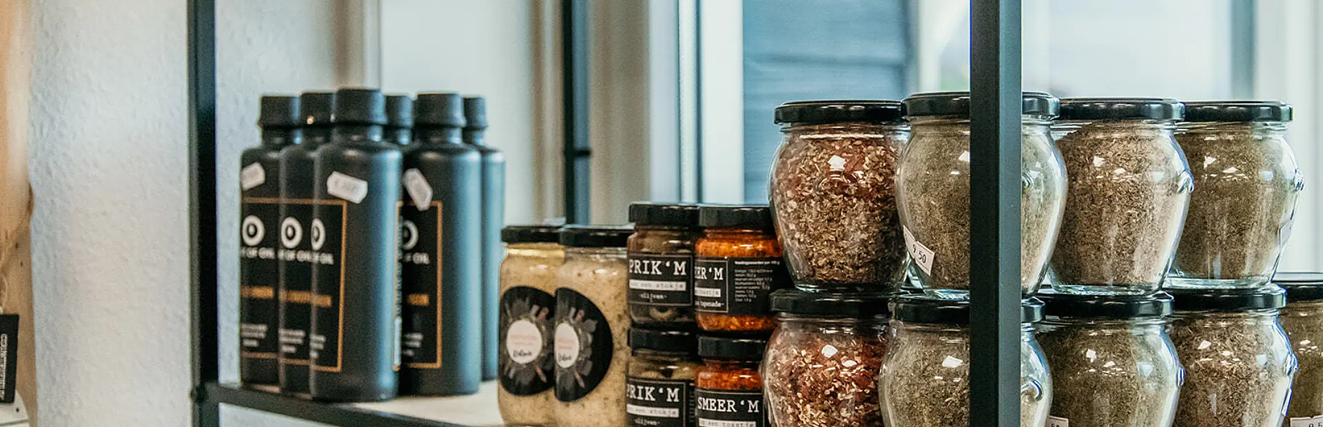 Schappen met streekproducten en delicatessen in de winkel van Strandpark De Zeeuwse Kust
