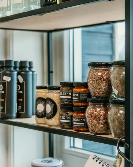 Schappen met streekproducten en delicatessen in de winkel van Strandpark De Zeeuwse Kust