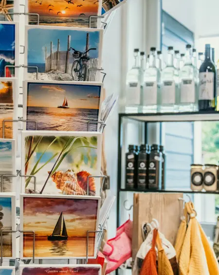 Rek met ansichtkaarten en lokale producten in de winkel van Strandpark De Zeeuwse Kust