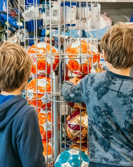 Twee jongens bekijken voetballen in de winkel van Strandpark De Zeeuwse Kust