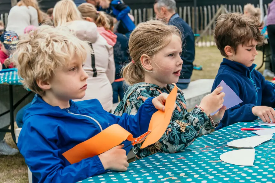 Kinderen knutselen samen tijdens een creatieve activiteit op het park