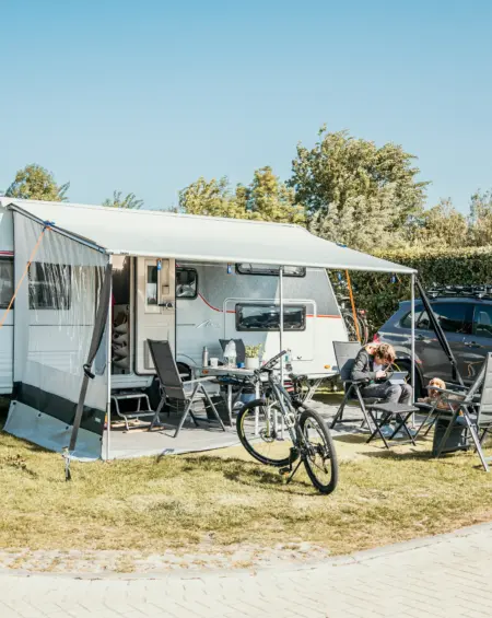 Ruime kampeerplek met caravan en voortent, perfect voor een ontspannen vakantie